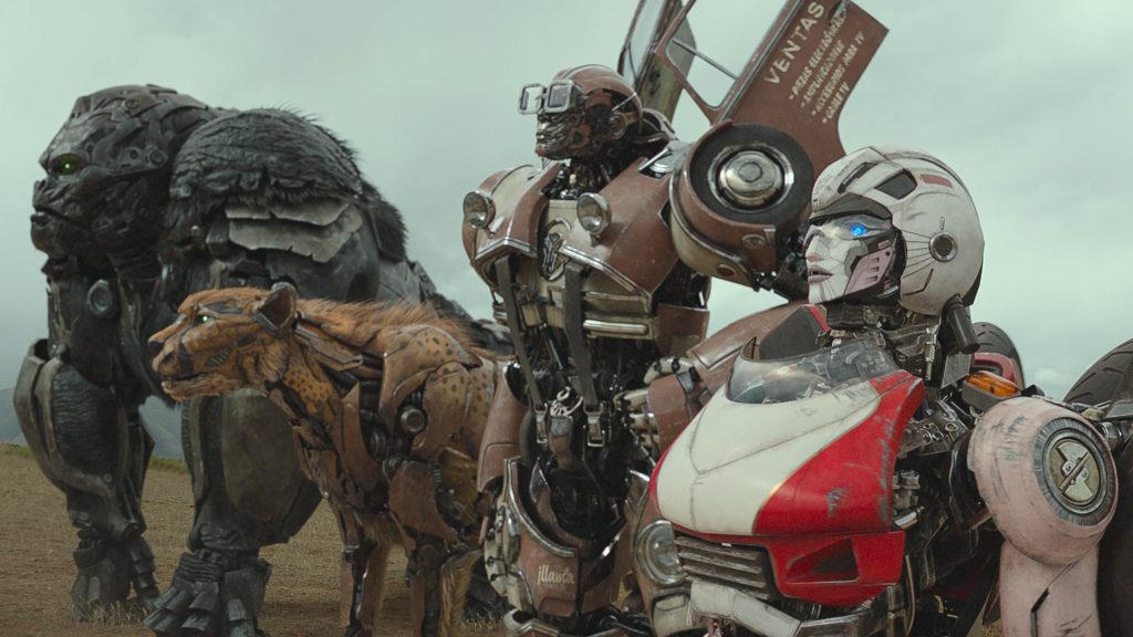 Maximal leader Optimus Primal stands next to Cheetor in his animal form and the autobots Wheeljack and Arcee in their classic inspired robot forms on the battlefield in TRANSFORMERS: RISE OF THE BEASTS.