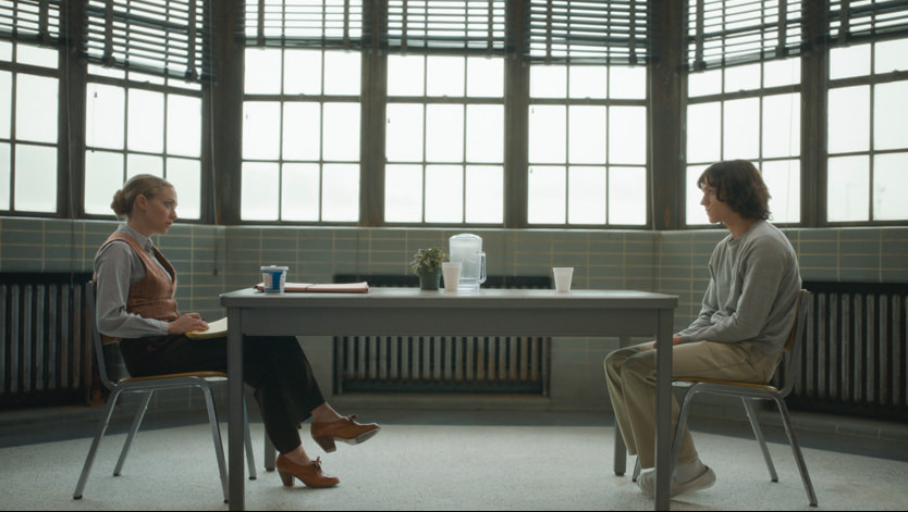 Amanda Seyfried as the investigator Rya Goodwin interviews Tom Holland as Danny Sullivan in a prison interrogation room in the limited psychological thriller series THE CROWDED ROOM on Apple TV+. 