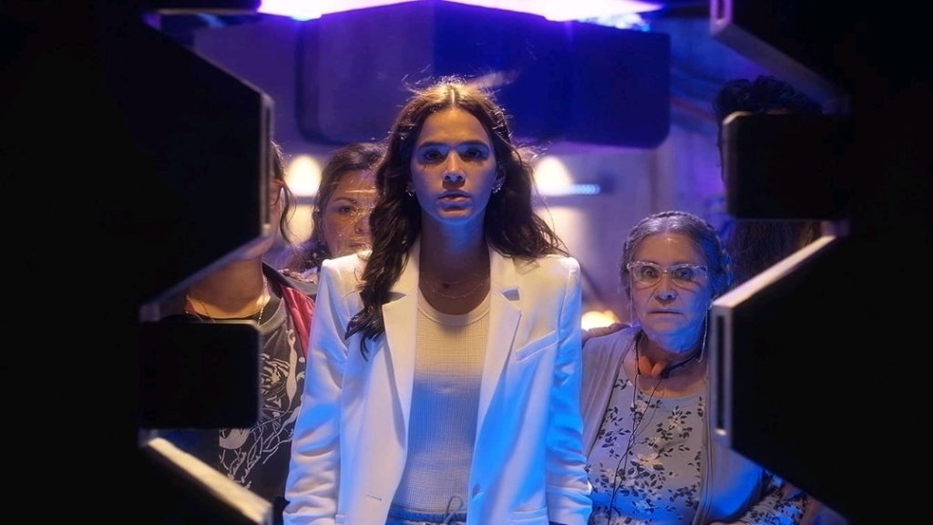 Belissa Escobedo, Elpidia Carrillo, Bruna Marquezine, and Adriana Barraza open up a vault of futuristic weapons to use in battle in the BLUE BEETLE movie. 