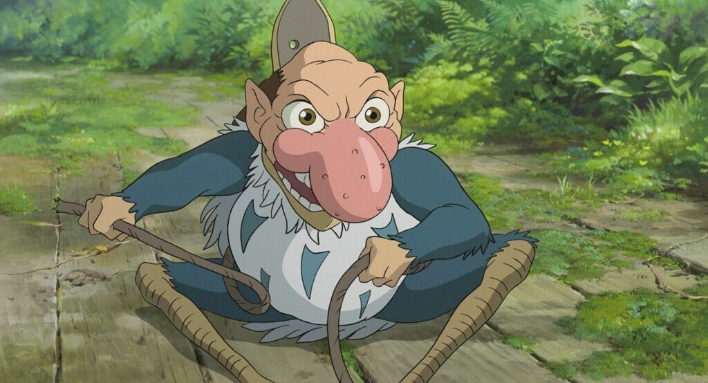 The mischievous grey heron with a human face and giant nose shows off a sinister smile in the animated film THE BOY AND THE HERON written and directed by Hayao Miyazaki. 