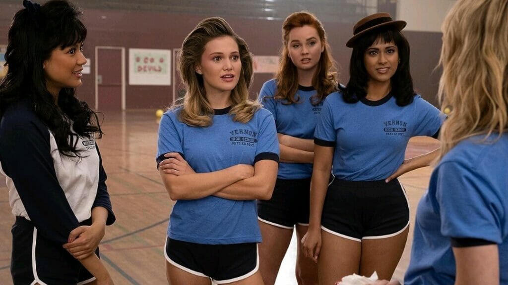 Liana Liberato, Olivia Holt, Stephi Chin-Salvo, and Anna Diaz pose together as quirky volleyball players in a high school gym during the '80s in the horror comedy TOTALLY KILLER streaming only on Amazon Prime Video.