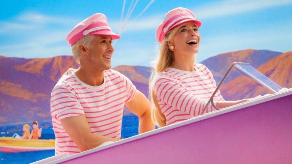 Margot Robbie and Ryan Gosling star as Barbie and Ken riding a pink boat while wearing pink striped shirts and pink sailing hats in Greta Gerwig's BARBIE movie coming to Max in December 2023.