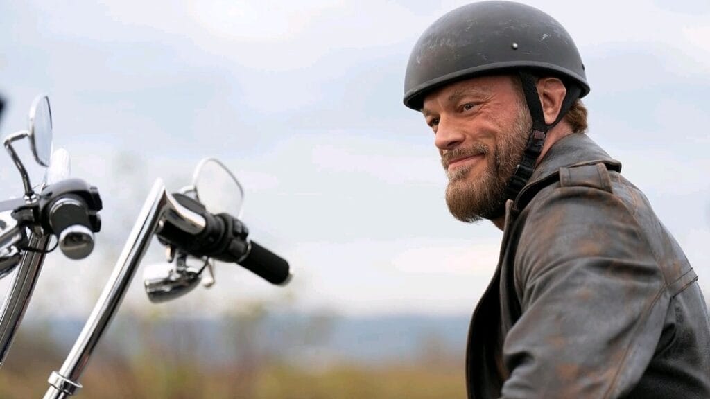 Adam Copeland, also known as WWE superstar the Edge, stars as Ares riding his motorcycle in a leather jacket in the PERCY JACKSON AND THE OLYMPIANS Disney+ series. 