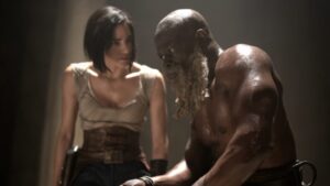 Kora played by Sofia Boutella tries to recruit General Titus played by Djimon Hounsou into her small band of warriors to fight the Motherworld in Zack Snyder's REBEL MOON on Netflix.