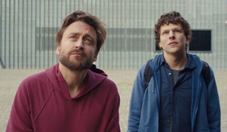 Jesse Eisenberg and Kieran Culkin as Jewish cousins David and Benji Kaplan look sad and confused standing next to each other in the movie A REAL PAIN.
