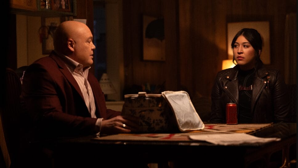 Vincent D'Onofrio as the Kingpin and Alaqua Cox as Maya Lopez sit together as he opens up a secret box on a table during a tense scene from Marvel's ECHO streaming on Disney+ and Hulu.