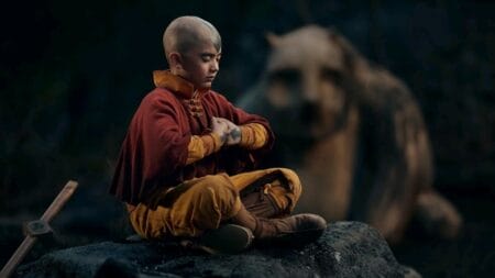 Aang played by Gordon Cormier meditates on top of a rock with his legs crossed with Hei Bai the forest spirit standing behind him in the live-action AVATAR: THE LAST AIRBENDER series premiering on Netflix in February 2024.
