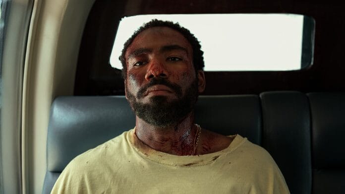 Donald Glover sports a stern face as his clothes look battle damaged in the new Mr. & Mrs. Smith show now streaming on Amazon Prime Video in February 2024.