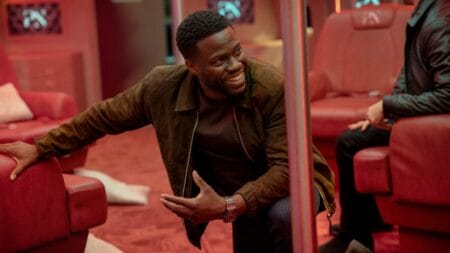 Kevin Hart in costume as master international thief Cyrus Whittaker shares a laugh in a behind-the-scenes photo from the set of the Netflix action comedy LIFT.