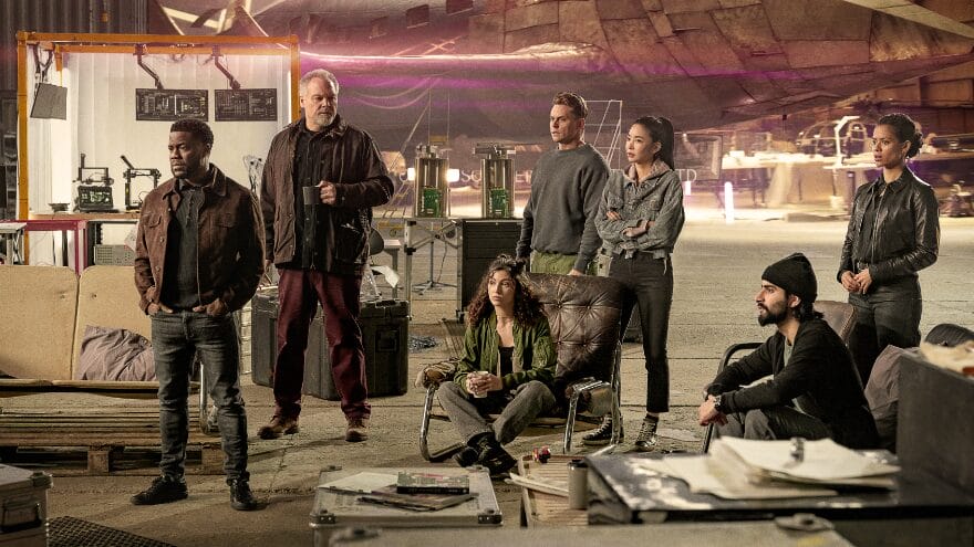 Kevin Hart and his international heist crew played by Vincent D’Onofrio, Úrsula Corberó, Billy Magnussen, Yun Jee Kim, Viveik Kalra, & Gugu Mbatha-Raw pose together  as they devise a plan in their safe house in the Netflix action comedy LIFT. 