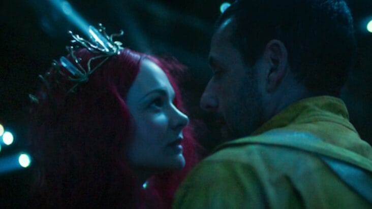 Carey Mulligan sporting red hair and wearing a golden tiara embraces Adam Sandler with a hug in the Netflix sci-fi movie SPACEMAN.