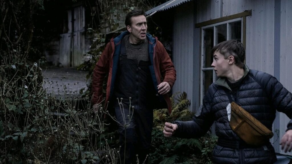Nicolas Cage and young actor Maxwell Jenkins run away from danger together in the action horror film ARCADIAN.