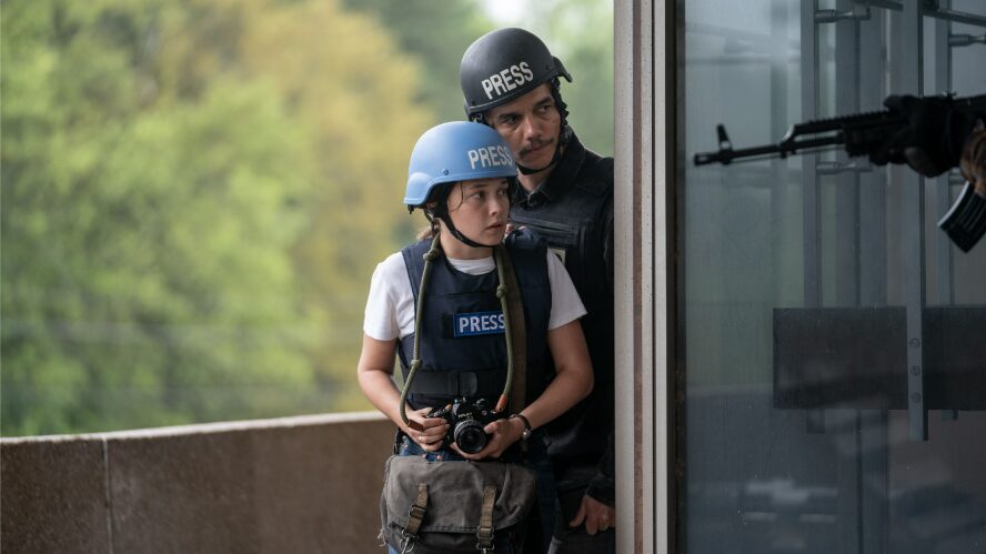 Cailee Spaeny and Wagner Moura walk behind enemy lines as journalists in their press uniforms and protective gear in CIVIL WAR written and directed by Alex Garland.