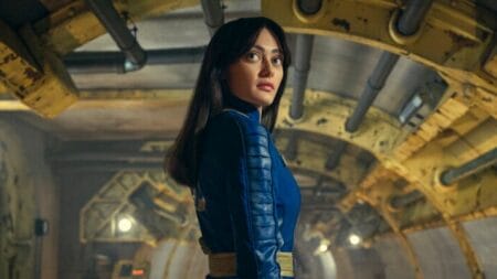 Ella Purnell strikes a pose as Lucy MacLean in her blue and yellow vault costume in Amazon's live-action FALLOUT series on Prime Video.