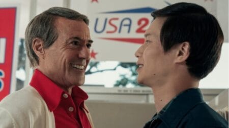 Robert Downey Jr. stars as the blonde Republican Congressman Ned Godwin giving a huge creepy smile next to The Captain played by Hoa Xuande in the HBO original miniseries THE SYMPATHIZER.