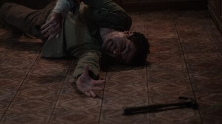 Christopher Abbott struggles to reach for a hammer as he lies on the floor, slowing morphing into a werewolf in WOLF MAN written and directed by Leigh Whannell.