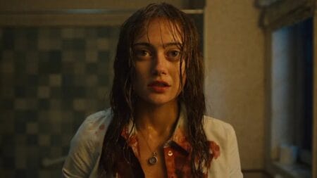 Ella Purnell stars as the main character Rhiannon Lewis starring into the bathroom mirror with her hair wet and white shirt covered in blood from the SWEETPEA series.