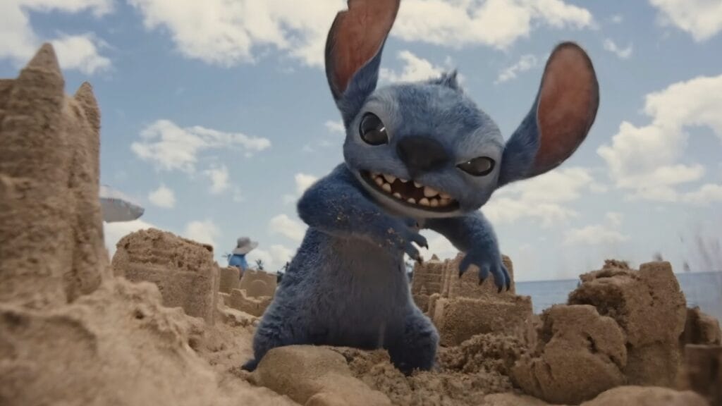 Live-action Stitch destroys a bunch of large sandcastles on a Hawaiian beach in the upcoming LILO & STITCH remake, which we predict will be a box office hit in our top 10 movie predictions of 2025 list.