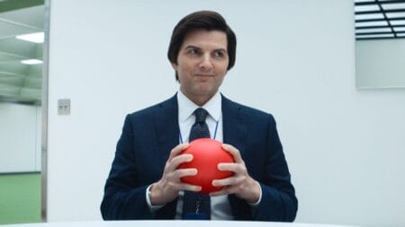 ‘Severance’ Season 2 Review – An Amazing Return to Lumon’s Halls Lumon Industries employee and severed worker Mark Scout, played by Adam Scott, gives off a huge smile while holding a small bright red rubber ball in SEVERANCE Season 2 streaming only on Apple TV+.