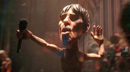 Anthony Kiedis as a wooden marionette puppet on strings rocks the stage with a mic in his hand in LOVE, DEATH + ROBOTS Volume 4 which is included in the Netflix May 2025 list of new movies and TV shows.
