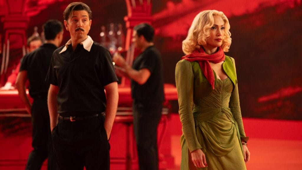 Diego Luna and Jennifer Lopez stun in Old Hollywood costumes on a vibrant red dance hall set during one of the many technicolor musical numbers of KISS OF THE SPIDER WOMAN.