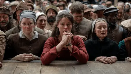 ‘Hamnet’ Review – Chloé Zhao and Jessie Buckley Craft a New Cathartic Masterpiece Jessie Buckley stars as Agnes Shakespeare holding up her hands in a praying position as she leans onto a large wooden outdoor theatre stage in front of a packed crowd of spectators in director Chloé Zhao's HAMNET.