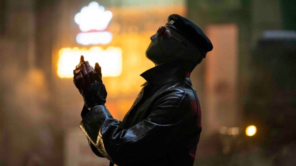 Lee Pace stars as Hunter leader Evan McCone wearing a beret with his face fully covered by a white mask and sunglasses in THE RUNNING MAN directed by Edgar Wright.