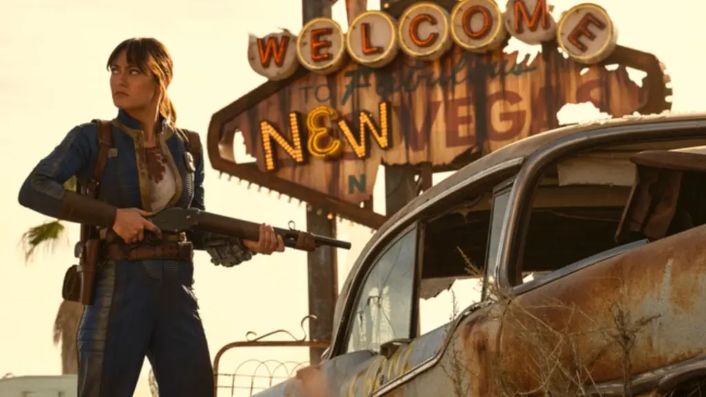 ‘Fallout’ Season 2 Review – A Confident Yet Slightly Uneven Continuation Ella Purnell stars as vault dweller Lucy in FALLOUT Season 2, standing in front of the iconic New Vegas neon sign from the games while holding a large rifle.