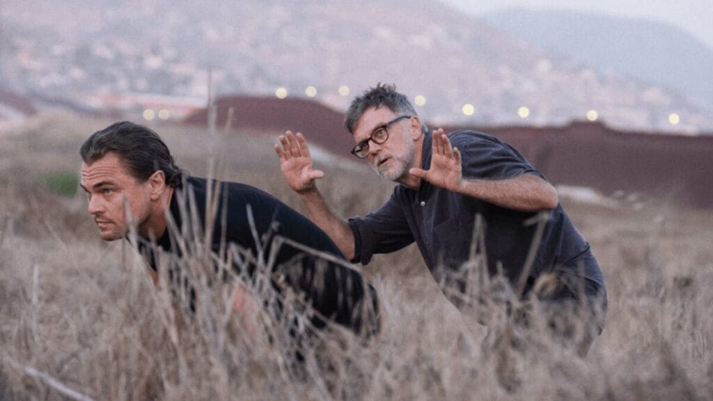Director Paul Thomas Anderson frames a shot of actor Leonardo DiCaprio sneaking through a large dry field in his political drama ONE BATTLE AFTER ANOTHER.