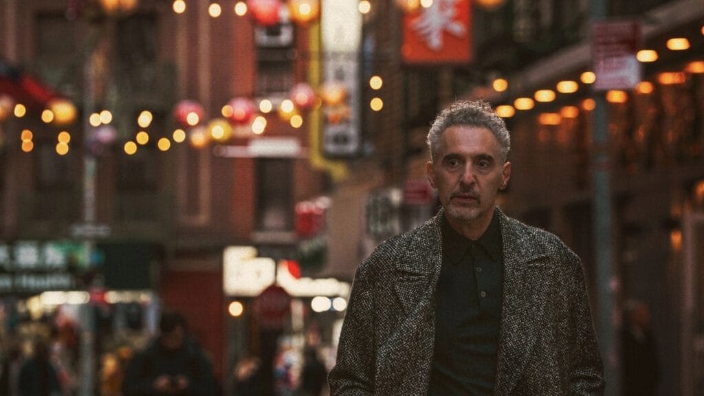 A shot of John Turturro walking down a busy street in THE ONLY LIVING PICKPOCKET IN NEW YORK, which is premiering at Sundance 2026.