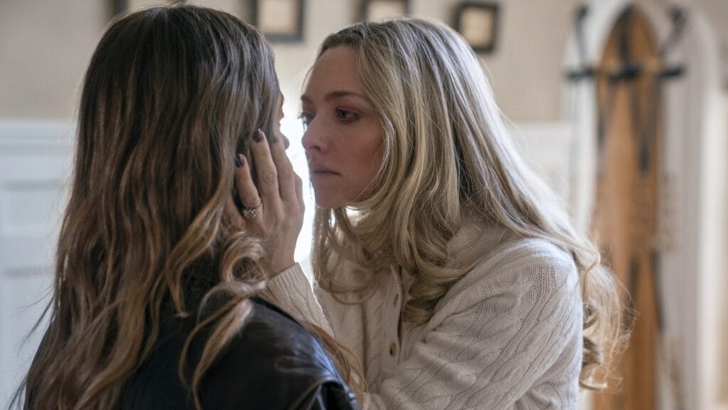Amanda Seyfried looks insane as she grabs hold of Sydney Sweeney's face and pulls it close to hers in the campy psychological thriller film THE HOUSEMAID. 