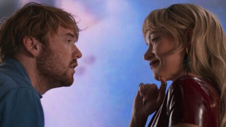 Cooper Hoffman and Olivia Wilde stare passionately into each other at a colorful art gallery in Gregg Araki's comeback film I WANT YOUR SEX.