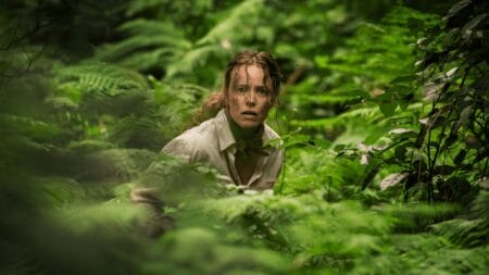 Rachel McAdams looks terrified in the middle of a luscious island forest in Sam Raimi's horror thriller SEND HELP.