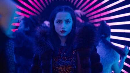 Ana de Armas stars as the assassin Eve Macarro looking cool as she walks through a tunnel with people dancing all around her in a club filled with neon purple lights in the John Wick spin-off film BALLERINA, which is included in the HBO Max March 2026 list of new movies and TV shows.