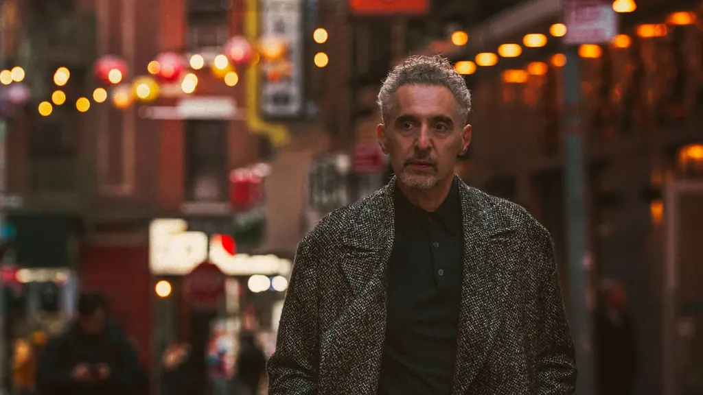 John Turturro stars as Harry Lehman, a veteran pickpocket thief walking down a busy New York City street with dazzling lights while wearing a salt-and-pepper colored cashmere overcoat in THE ONLY LIVING PICKPOCKET IN NEW YORK.