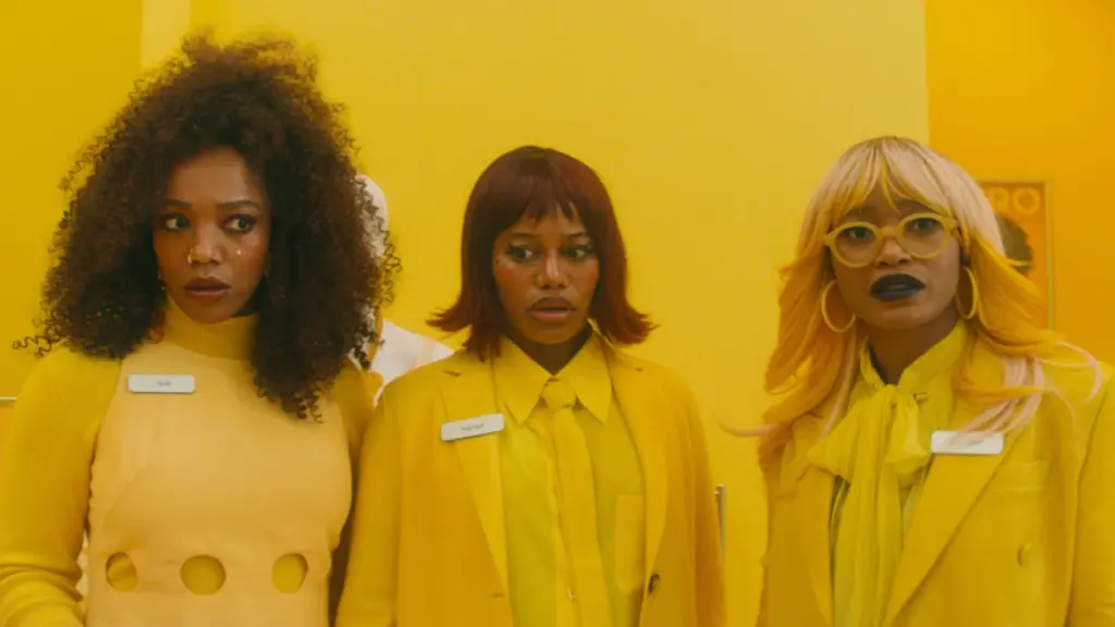 Naomi Ackie, Taylour Paige, and Keke Palmer make funny faces while wearing chic bright yellow outfits in Boots Riley's I LOVE BOOSTERS.