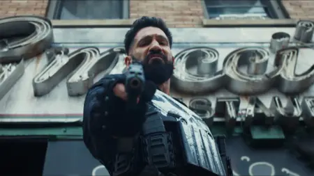 Jon Bernthal stars as Frank Castle wearing a new black suit with a bright white skull logo on his chest while holding a shotgun down towards the camera in the Marvel Television Special Presentation THE PUNISHER: ONE LAST KILL.