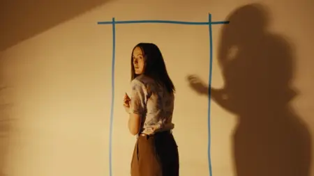 New Arrivals for HBO Max September 2026 Renate Reinsve turns to the camera with a terrified look on her face while standing in front of a yellow wall with a blue door drawn on it in the hit A24 horror film BACKROOMS, which is included in the HBO Max September 2026 list of new movies and TV shows.
