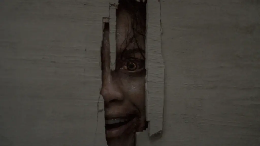 Luciane Buchanan stars as a Deadite breaking through a wooden door and looking into the camera with a sinister smile in EVIL DEAD BURN, which is included in the HBO Max October 2026 list of new movies and TV shows.