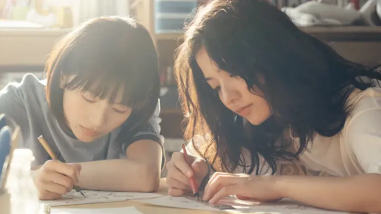 Natsuki Deguchi and Aju Makita star as main characters Fujino and Kyomoto drawing comic strips together in a small intimate bedroom in the live-action Manga adaptation of LOOK BACK.