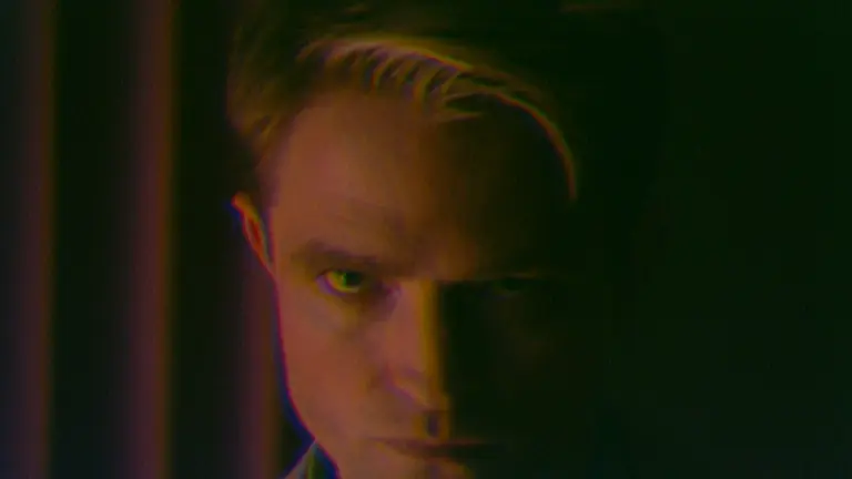 A close-up shot of actor Robert Pattinson looking into the camera menacingly as To Catch a Predator host Chris Hansen in the movie PRIMETIME.