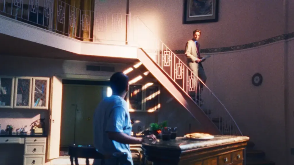 Chris Hansen, played by Robert Pattinson, walks down a long flight of stairs in a pink-colored house as he questions a supposed pedophile in a To Catch a Predator segment recreated in the movie PRIMETIME. 