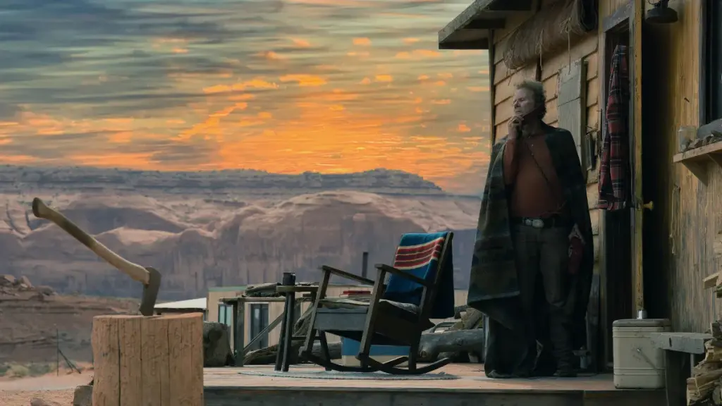 Tom Waits stands outside of a beautiful farmhouse in the black comedy action-thriller WILD HORSE NINE.