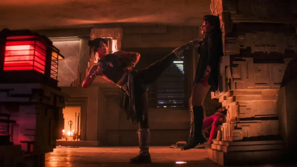 Callina Liang as Chun-Li holds up the villainous Bison doll Juli by the throat with her foot in the live-action STREET FIGHTER film.