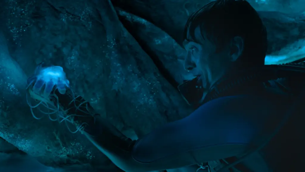 Austin Abrams holds up a bioluminescent jellyfish and uses it as a light source inside the claustrophobic stomach of a sperm whale in the epic survival thriller WHALEFALL. 